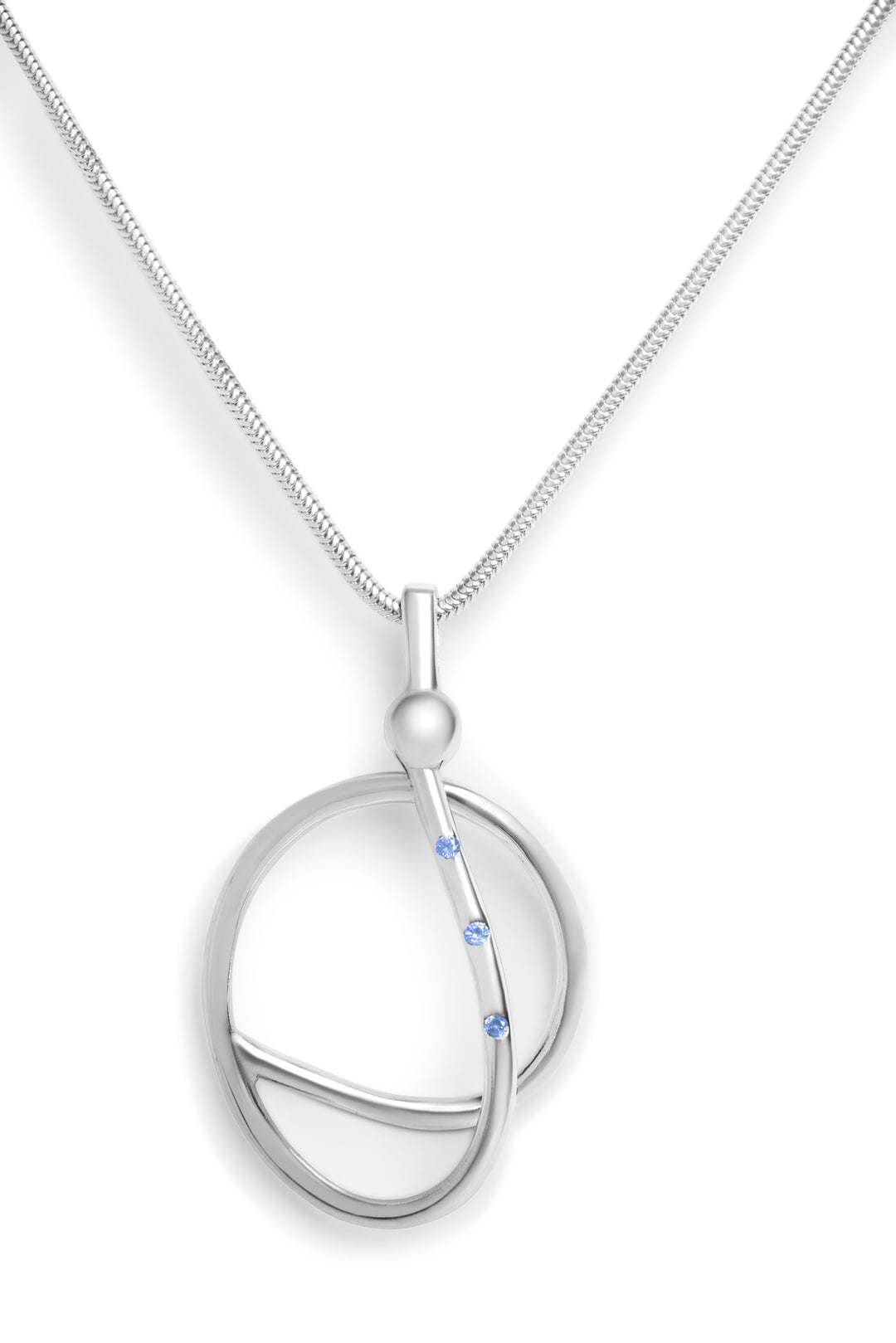 The Sea Honey Necklace by Gallardo & Blaine Designs features a modern sterling silver pendant with intersecting loops and three blue gemstones set along one curve.