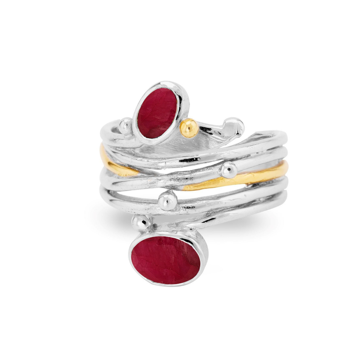 The Snake Ring in Silver Gold by Gallardo & Blaine Designs features wavy, layered bands with gold accents and two asymmetrically set oval red gemstones.