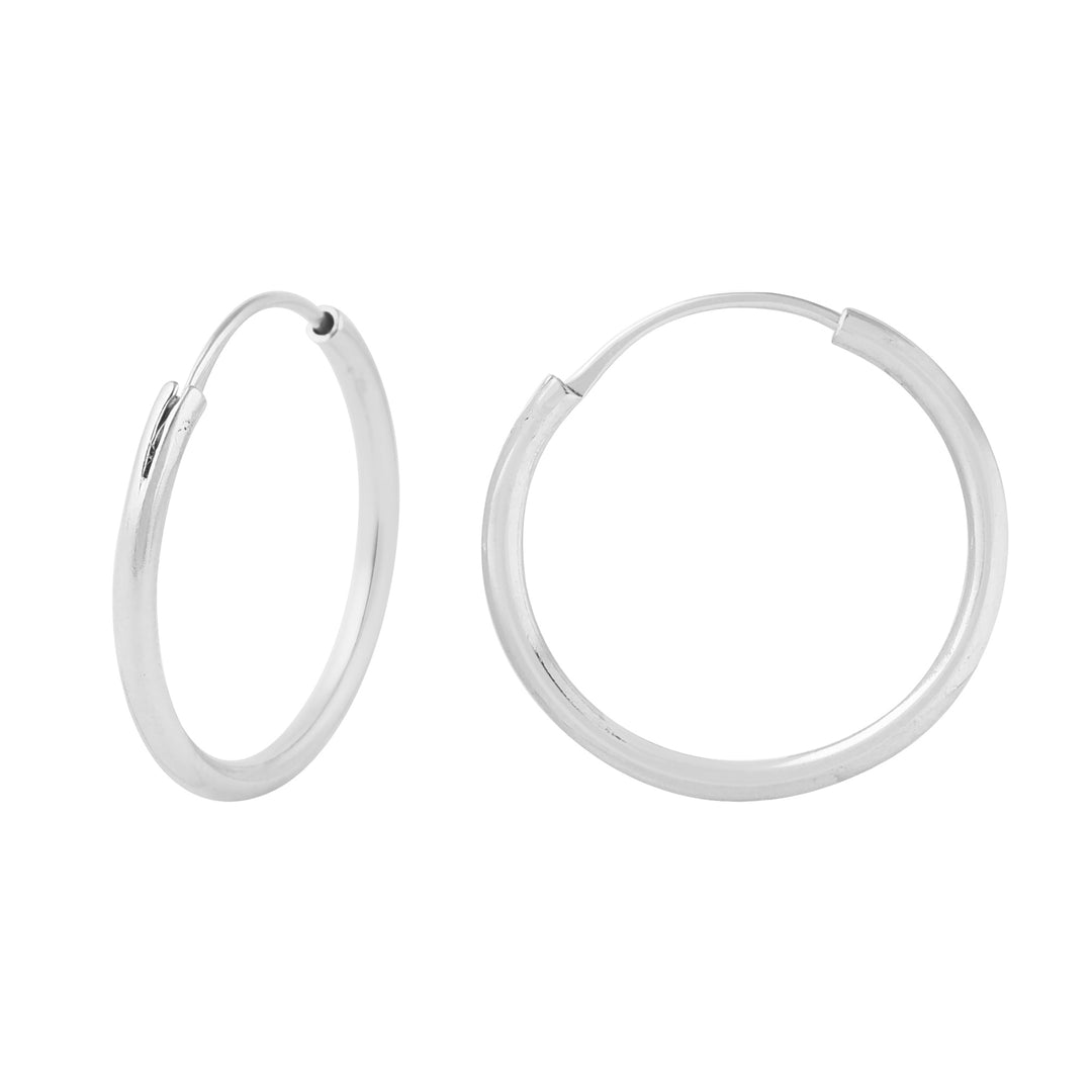 A pair of Watermelon tropical Laura Silver Hoops. One earring is open, showing the clasp mechanism, while the other is closed, displaying its smooth, polished surface. With a 20mm diameter, both earrings boast a sleek and minimalist design.