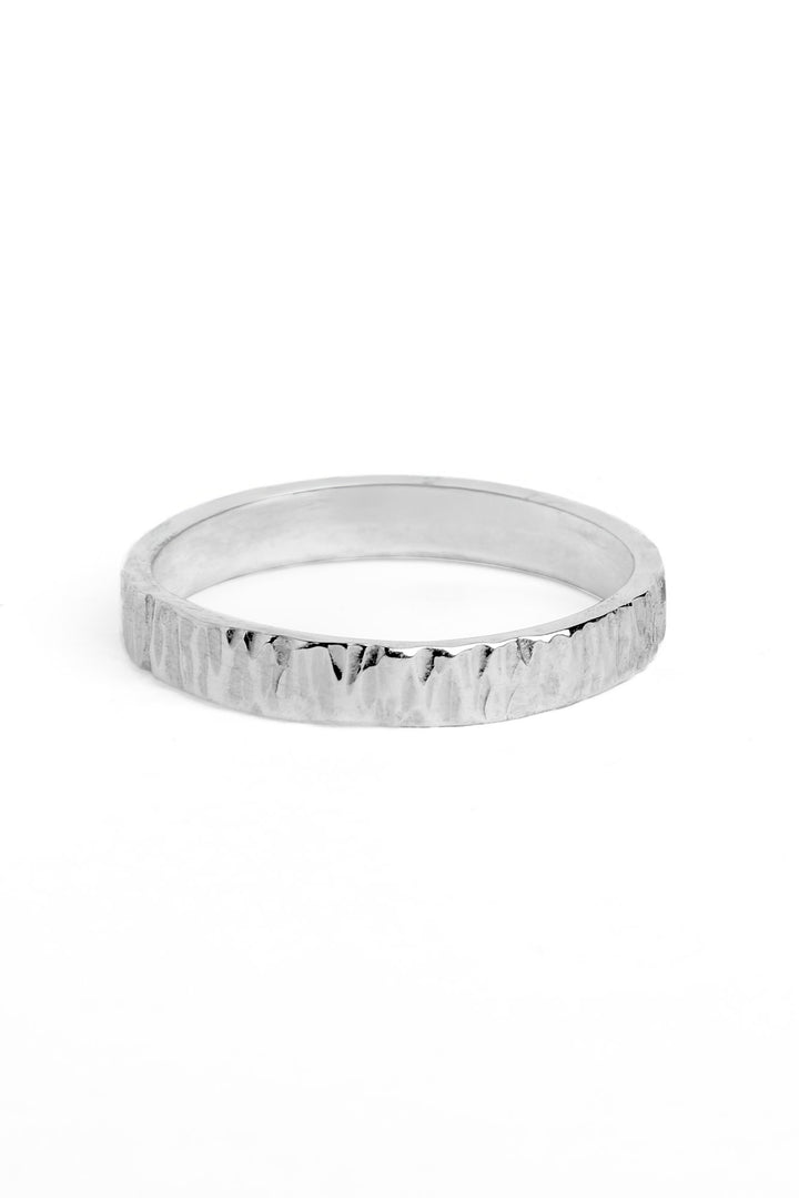 A flat sterling silver ring 4mm wide with a textured bark finish on the outside of the band.