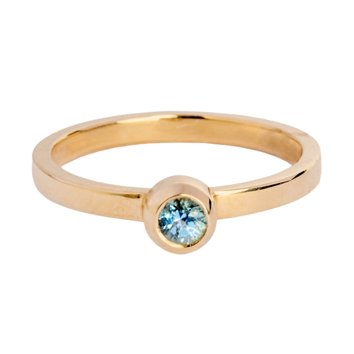 9ct yellow gold ring with a small round aquamarine in a bezel setting. The band is flat in shape and is 2mm wide. The stone is 3mm in diameter.