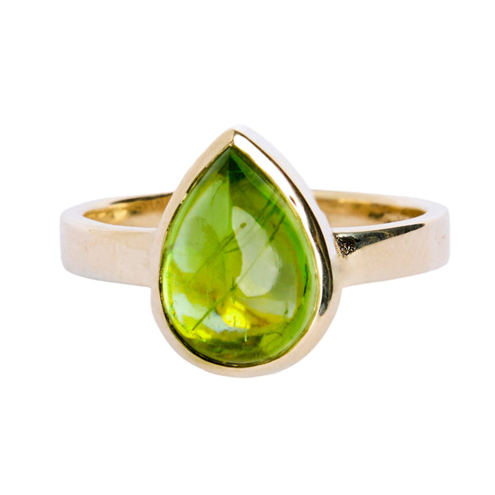 9ct yellow gold ring with a teardrop shaped peridot cabochon, which is a moss green gem, in a bezel setting. The band is flat in shape and is 3mm wide. The 9ct yellow gold band is 3mm wide.