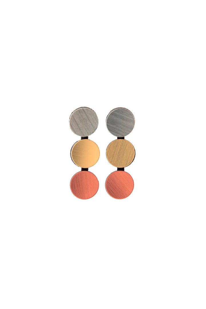 The Abstraction 3 Dots Earrings by Iskin Sisters are lightweight statement pieces showcasing vertically arranged tri-colour circular segments: a silver disc at the top, a gold disc in the middle, and a copper disc at the bottom. Each brushed metallic finish adds an elegant touch to these abstract earrings.