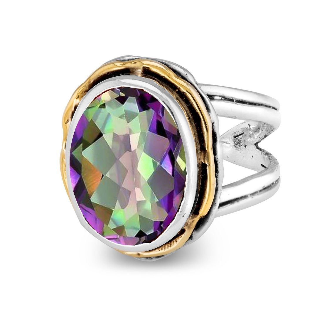 The Magnolia Ring by Gallardo & Blaine Designs features a silver split band with a wavy gold bezel, highlighting an oval faceted gemstone in green and purple hues.