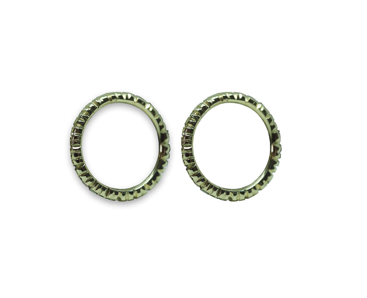 Two close-up views of identical wheel-like objects featuring a circular shape with ridged, gear-like edges. Resembling exquisitely crafted golden earrings, the Into The Light Circle Earrings 9ct Yellow Gold by Aud are positioned side by side against a plain white background, showcasing their hand-engraved details in yellow gold.