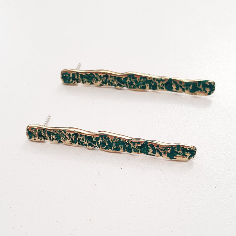 These earrings are designed in gold plated silver with cobalt blue or forest green crackle texture finish and stud back .