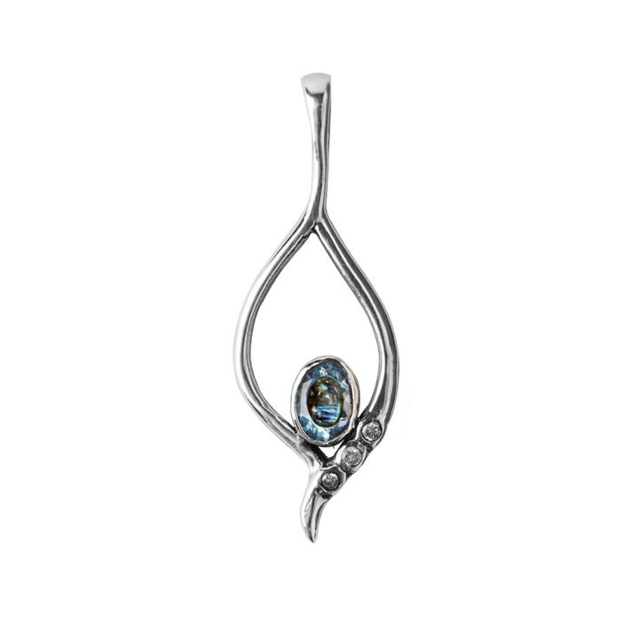 The Desert Star Pendant by Gallardo & Blaine Designs features an open teardrop design set in sterling silver, with an oval blue gemstone at the base and three clear stones arranged diagonally. Available in various gemstones.