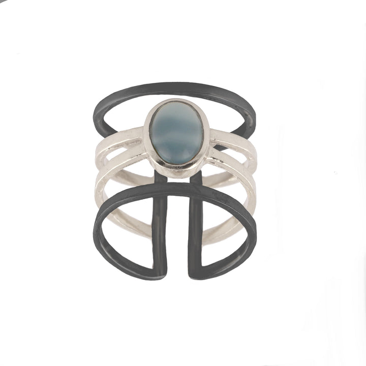 Introducing the Andi Banded Ring in Amazonite by Watermelon Tropical – a modern, minimalist sterling silver ring featuring an open, multi-band design with three thin interconnected bands and a central Amazonite stone. The aesthetic is heightened by two larger black bands that form an abstract shape around the silver bands.