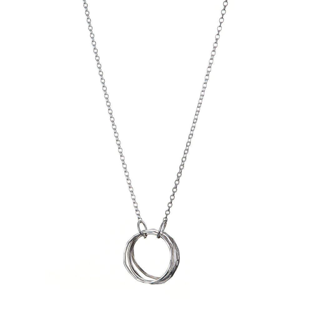 A delicate silver necklace featuring a simple design with a five circle link pendant. The fine and minimalistic chain allows the intertwined rings to be the focal point of this sterling silver jewelry piece, the Doorus Silver Pendant by Lynsey de Burca.