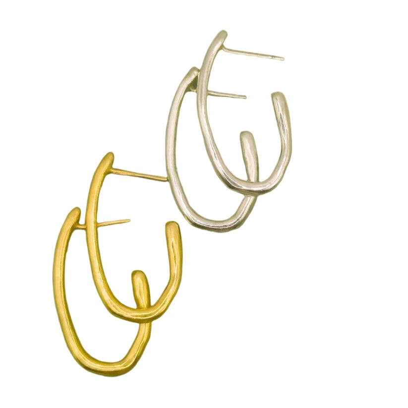 Two pairs of Drop Organic Hoop Earrings by Inó Jewellery—one gold, one silver—are arranged diagonally on white. Each pair features a modern double oval hoop design from our handmade Rustic Collection.