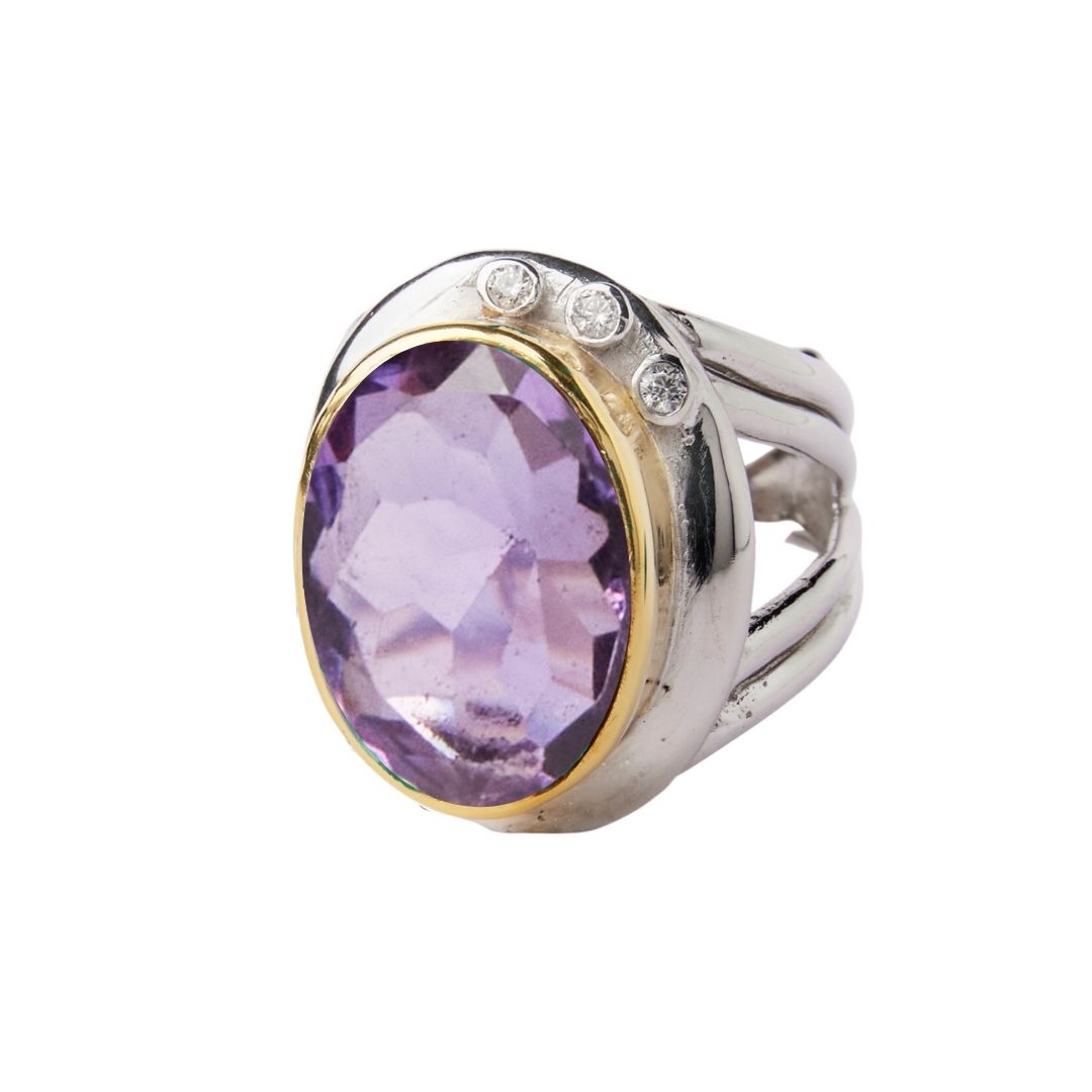 The Eyetelia Ring by Gallardo & Blaine Designs features a large oval-cut purple gemstone in sterling silver gold vermeil, accented with three small round diamonds on one side for an elegant statement look.
