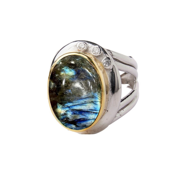 The Eyetelia Ring by Gallardo & Blaine Designs features a large oval labradorite with blue-green hues set in gold bezel on sterling silver vermeil, accented by three round diamonds above the adjustable gemstone.