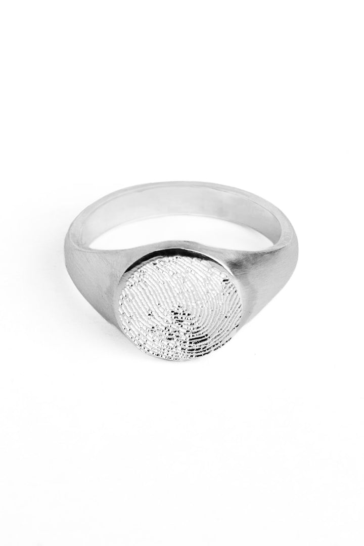 The Engraved Fingerprint Sterling Silver Round Signet Ring by Personalised Charms features a flat, round top with an engraved fingerprint design, shown against a plain white background.
