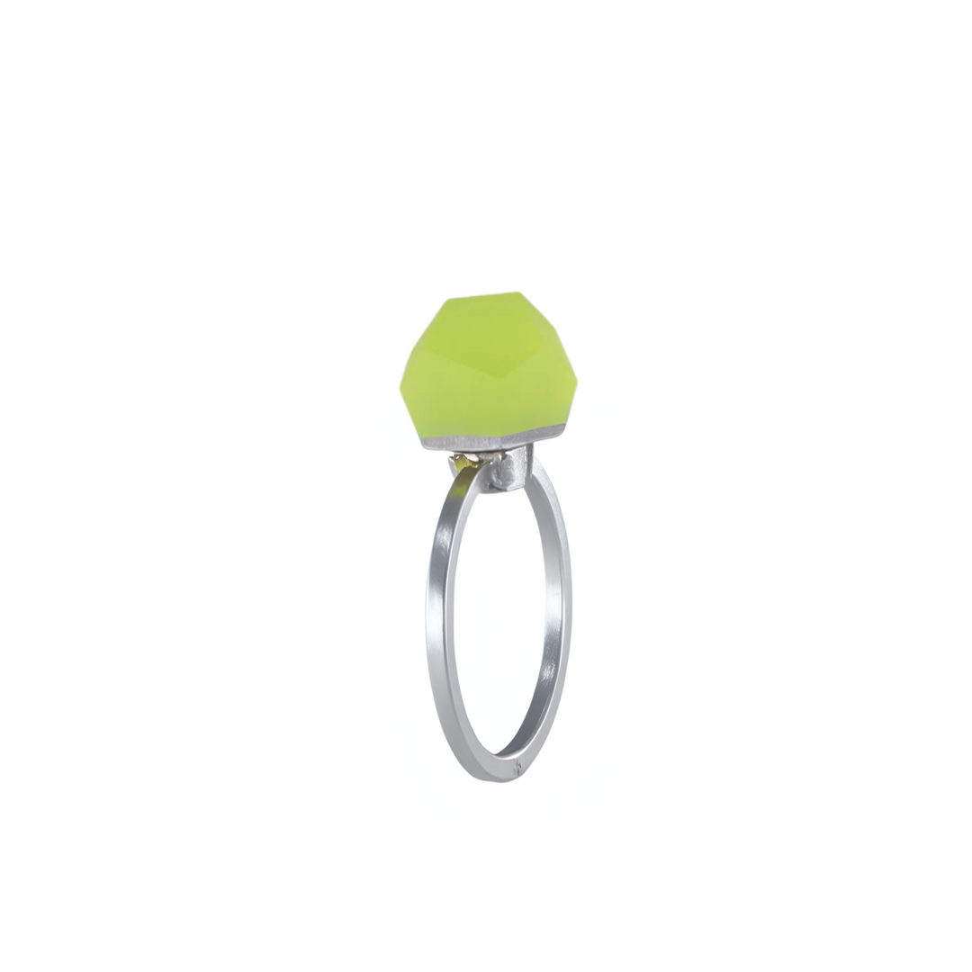 The Fruit Bijoux Ring Top VU Crystals Neon Yellow by Fruit Bijoux features a faceted, geometric neon yellow-green stone set in sterling silver, showcased against a white background.