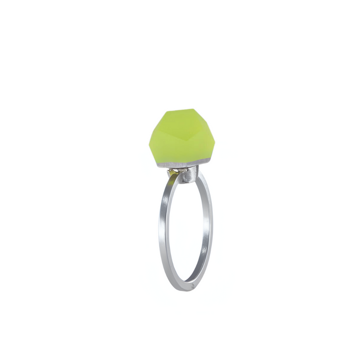 The Fruit Bijoux Ring Top VU Crystals Neon Yellow by Fruit Bijoux features a faceted, geometric neon yellow-green stone set in sterling silver, showcased against a white background.