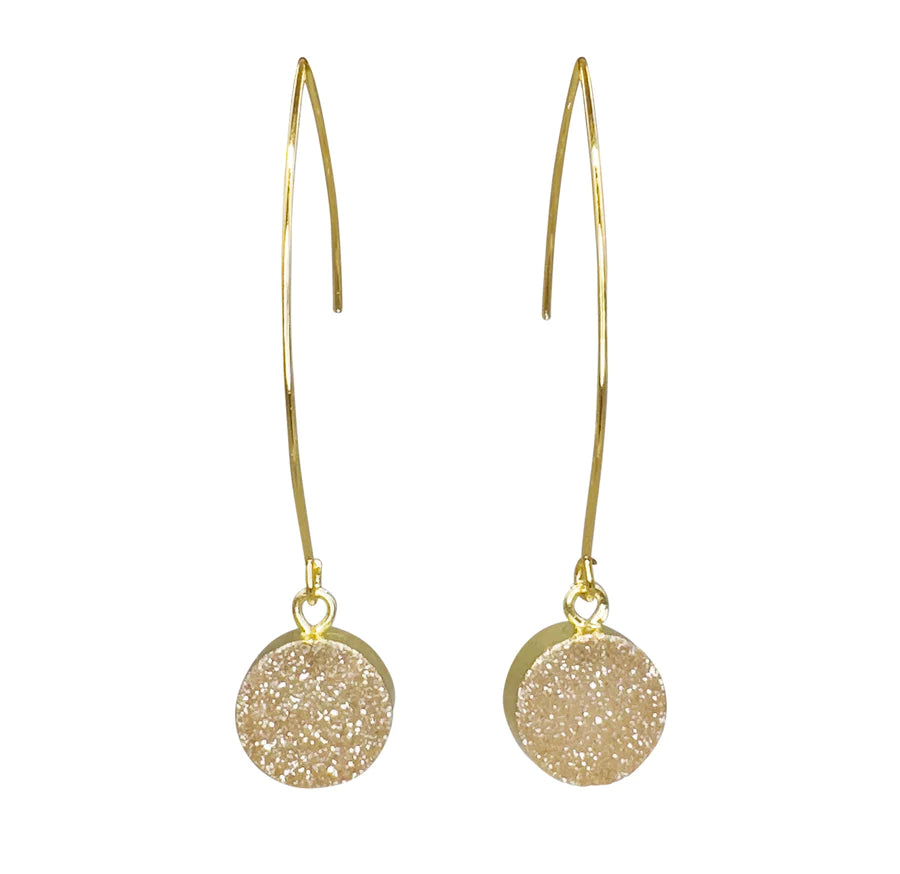 A pair of elegant, long, gold dangle Aria V Gigi Earrings with simple, curved hooks. Each handcrafted earring features a round, shimmery beige druzy stone pendant made from natural stones that adds a touch of sparkle and sophistication.