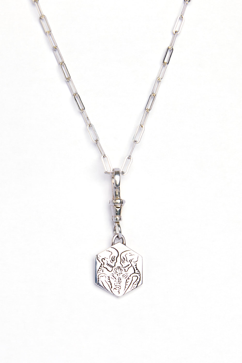The Lovers Silver Pendant by Cosmic Boulevard features a rectangular chain and geometric pendant engraved with an abstract animal face, captured on a white background—a modern, subtle symbol of love.