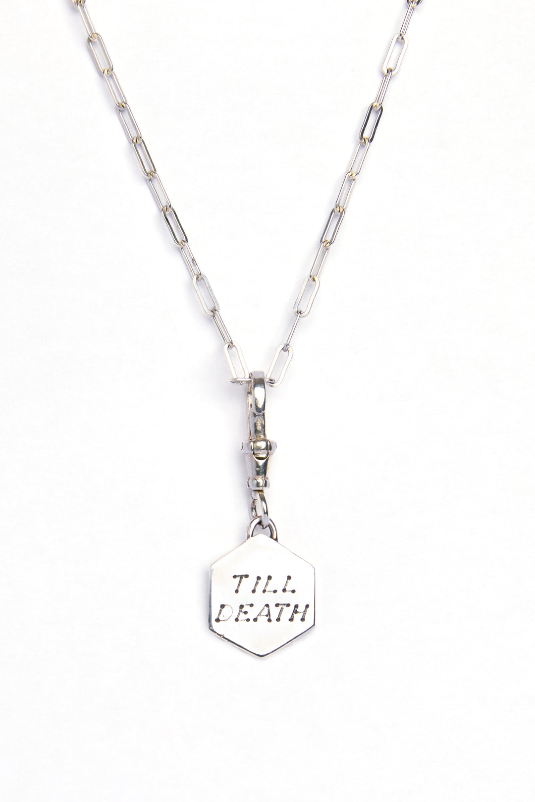 The Lovers Silver Pendant by Cosmic Boulevard features a hexagonal sterling silver pendant engraved with "TILL DEATH," hanging from a silver chain and displayed against a white background.