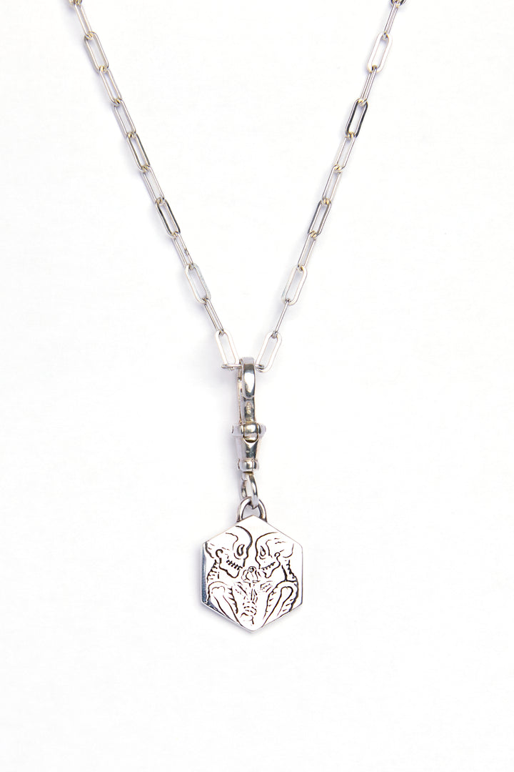 The Lovers Silver Pendant by Cosmic Boulevard features sterling silver elongated chain links and a hexagonal charm engraved with a stylized wolf face, shown on a white background.