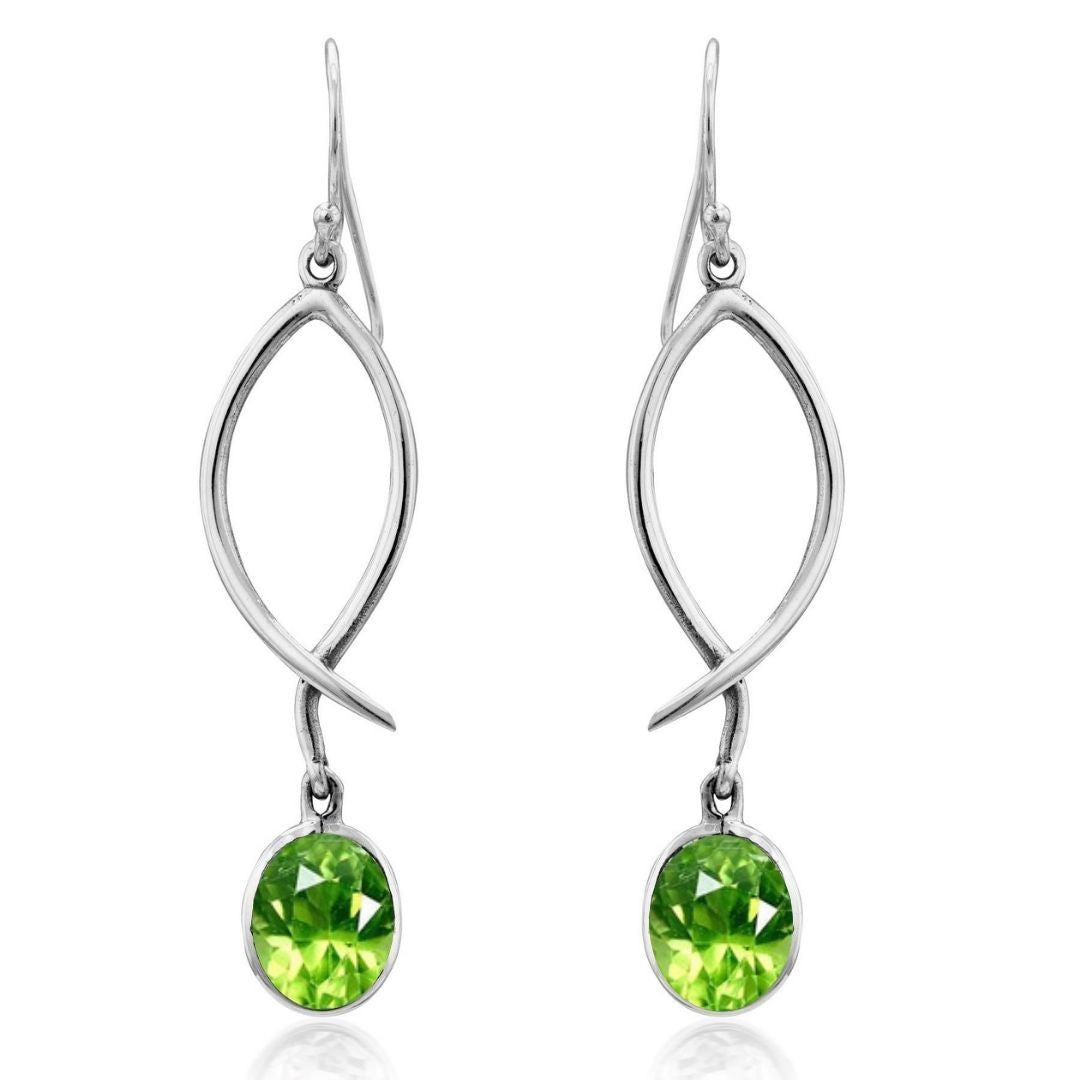 The Lupin Earrings by Gallardo & Blaine Designs feature open, leaf-like silver drops with round faceted green gemstones. Lightweight and elegant, they add nature-inspired charm to any outfit. Available in various gemstones.