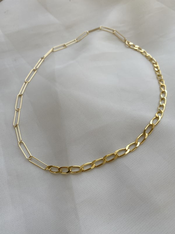 The Bonvo Mixed Links Necklace features both elongated rectangular and classic oval links in a striking gold-plated design, blending modern and timeless styles. Shown on a white fabric background.