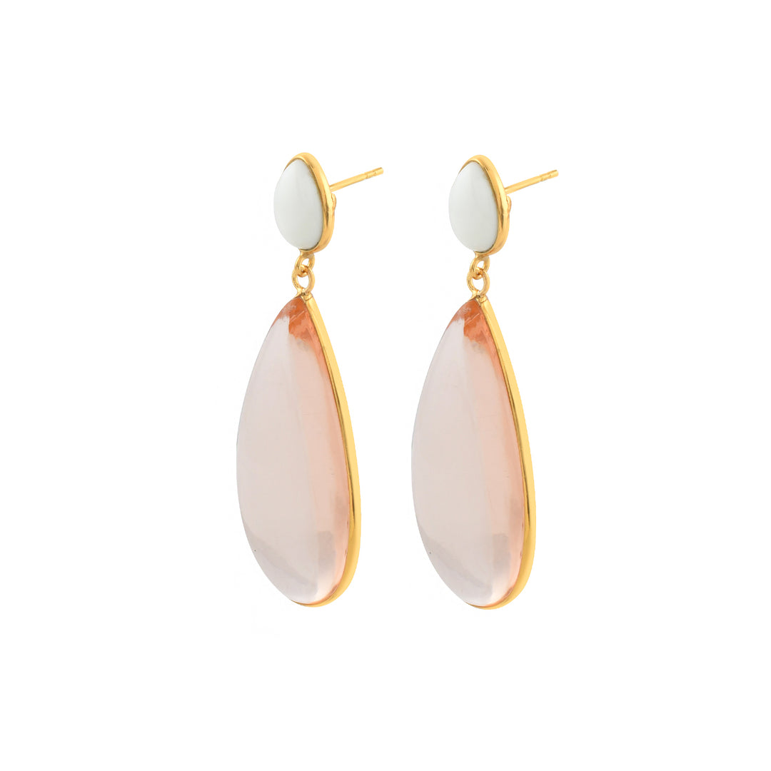 The Nancy Earrings by Shyla are gold on sterling silver statement earrings with glass oval white studs and large faceted pink teardrop stones.
