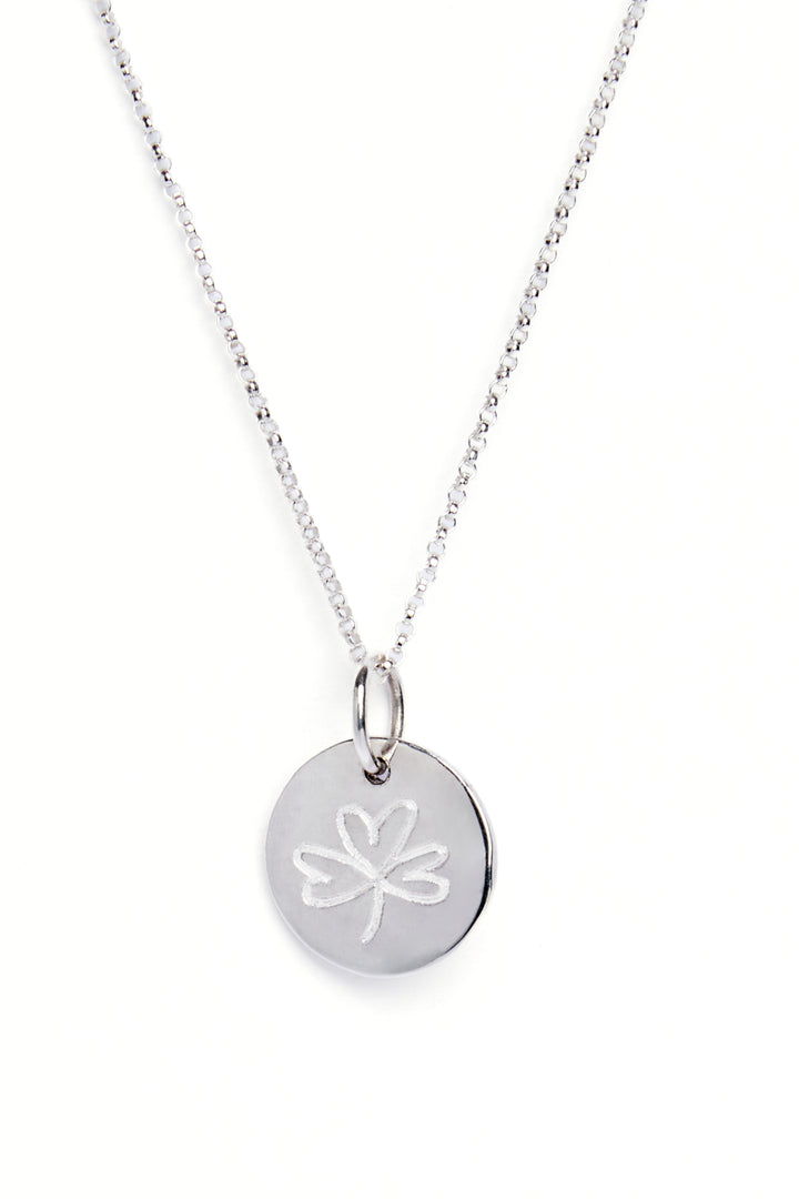A sterling silver necklace with a round organic shaped circle pendant measuring 15mm in diameter which has a subtle indent in the centre. This pendant has been engraved with a shamrock on the reverse.