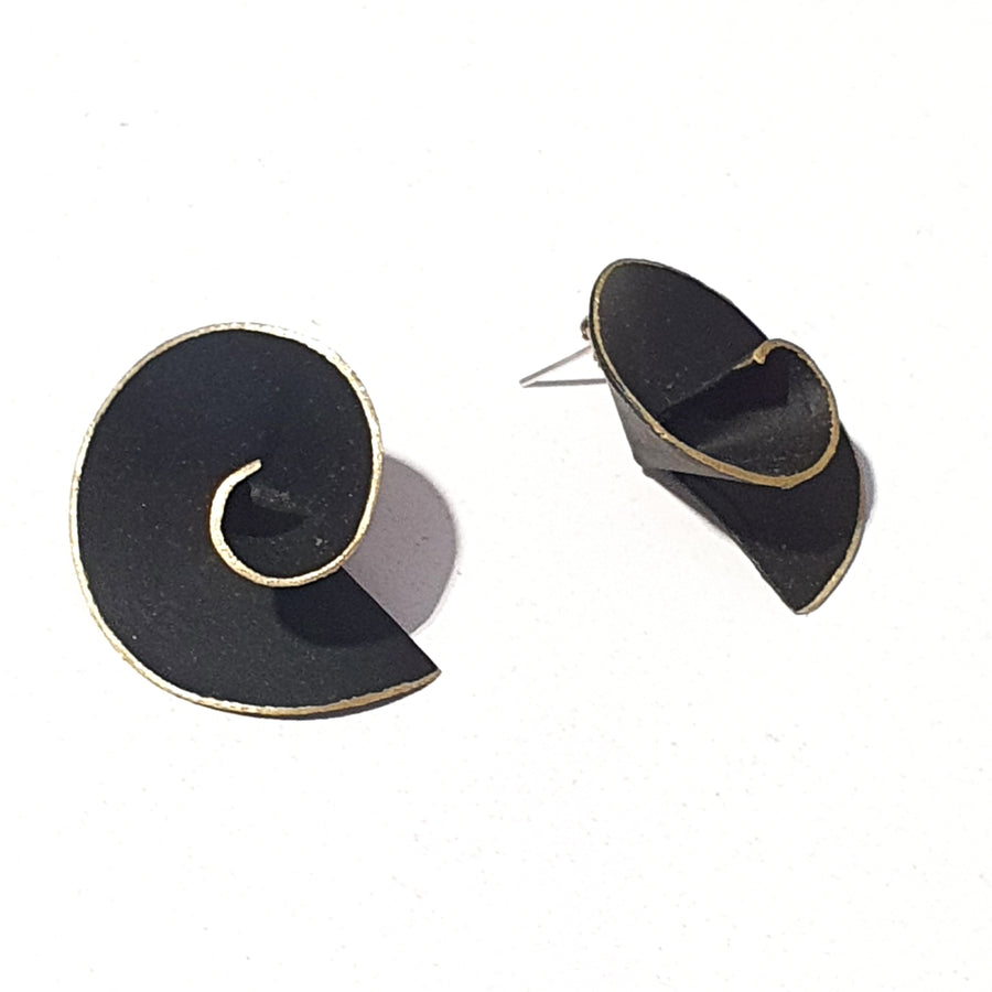These swirl earrings are designed in silver with cobalt blue or matt black pigment, gold plated finishing and stud back.