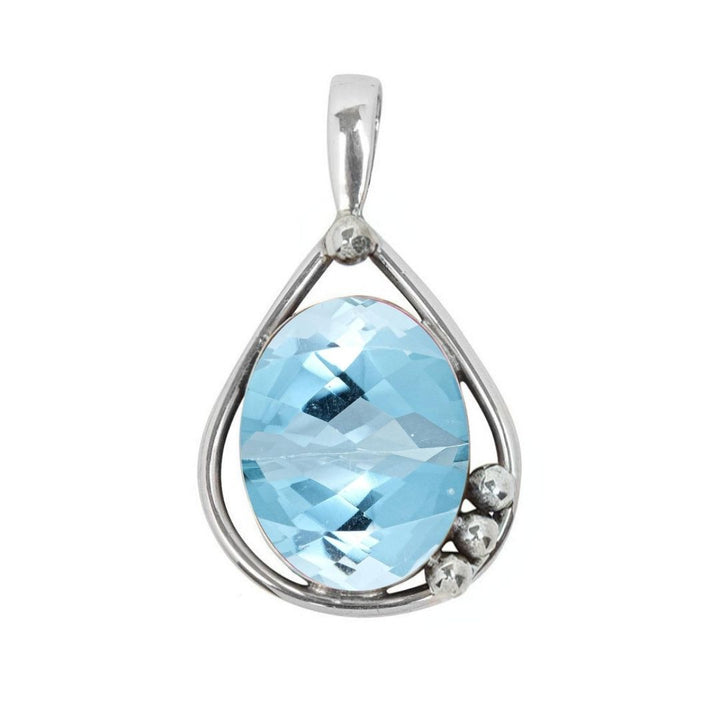 The Poppy Pendant Small by Gallardo & Blaine Designs features a silver teardrop shape with a faceted oval blue gemstone center and three small silver beads accenting the bottom right.