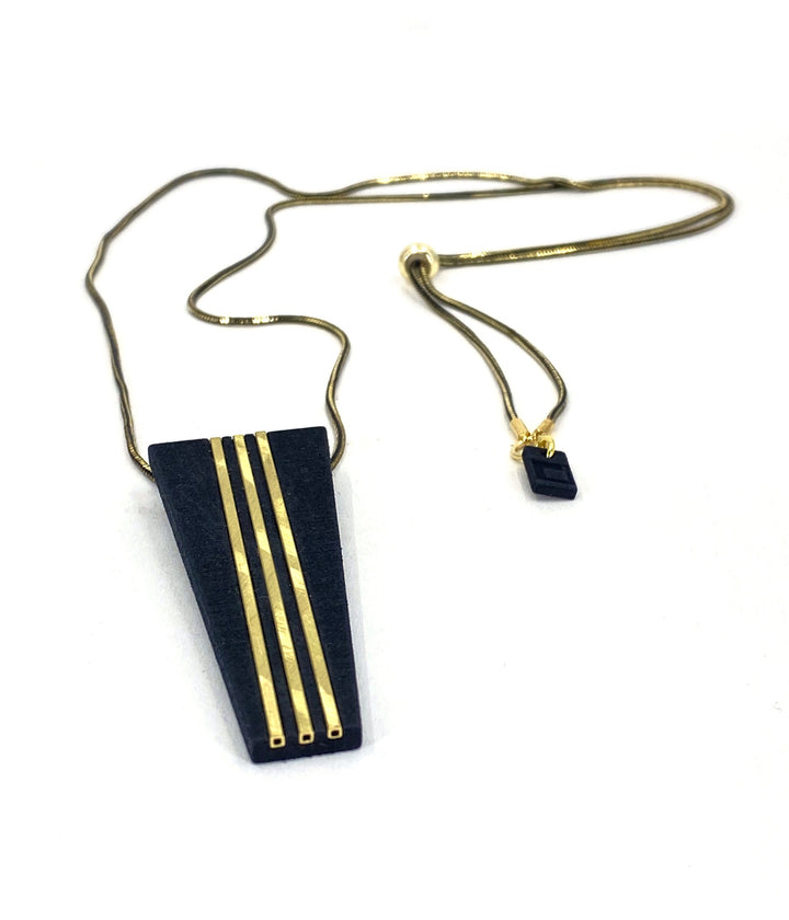 The Elsiem Rapture Warrior Necklace features a 3D-printed black trapezoidal pendant with three vertical gold lines and a matching charm on a slim black and gold snake chain, shown against a white background.