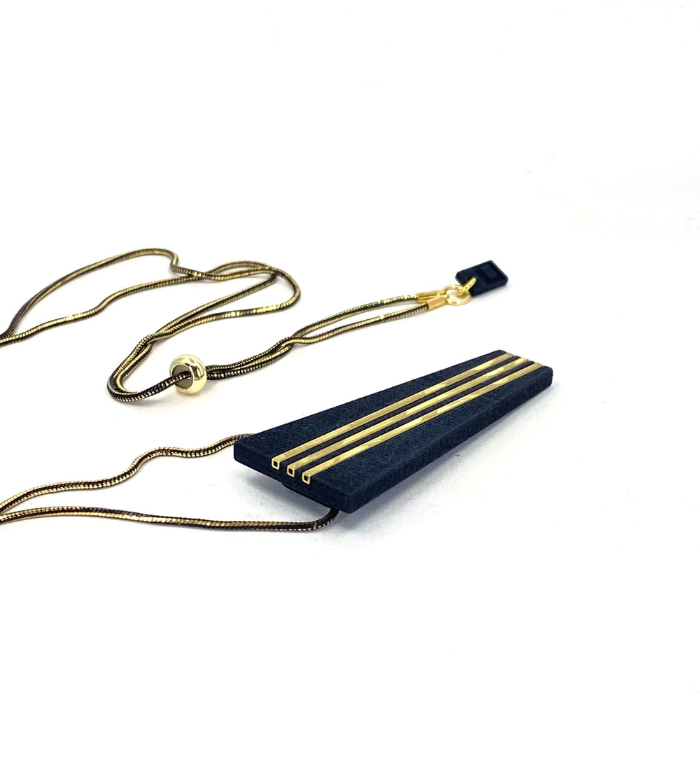 The Elsiem Rapture Warrior Necklace pairs a shiny gold and black snake chain with a modern, minimalist 3D-printed black pendant featuring four parallel gold lines and a sleek tapered rectangular shape.