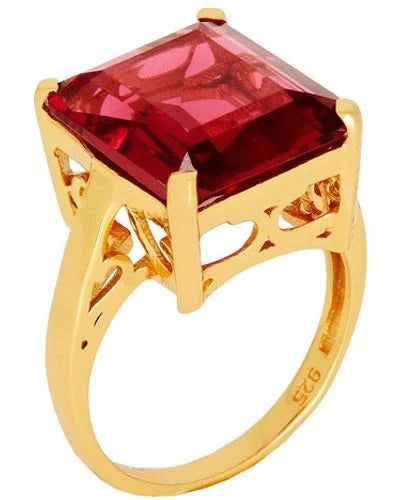 The Claudia Ring by Shyla is a gold chunky ring with an ornate band, featuring a large, square-cut red gemstone in a prong setting and “925” stamped inside for vintage-inspired charm.