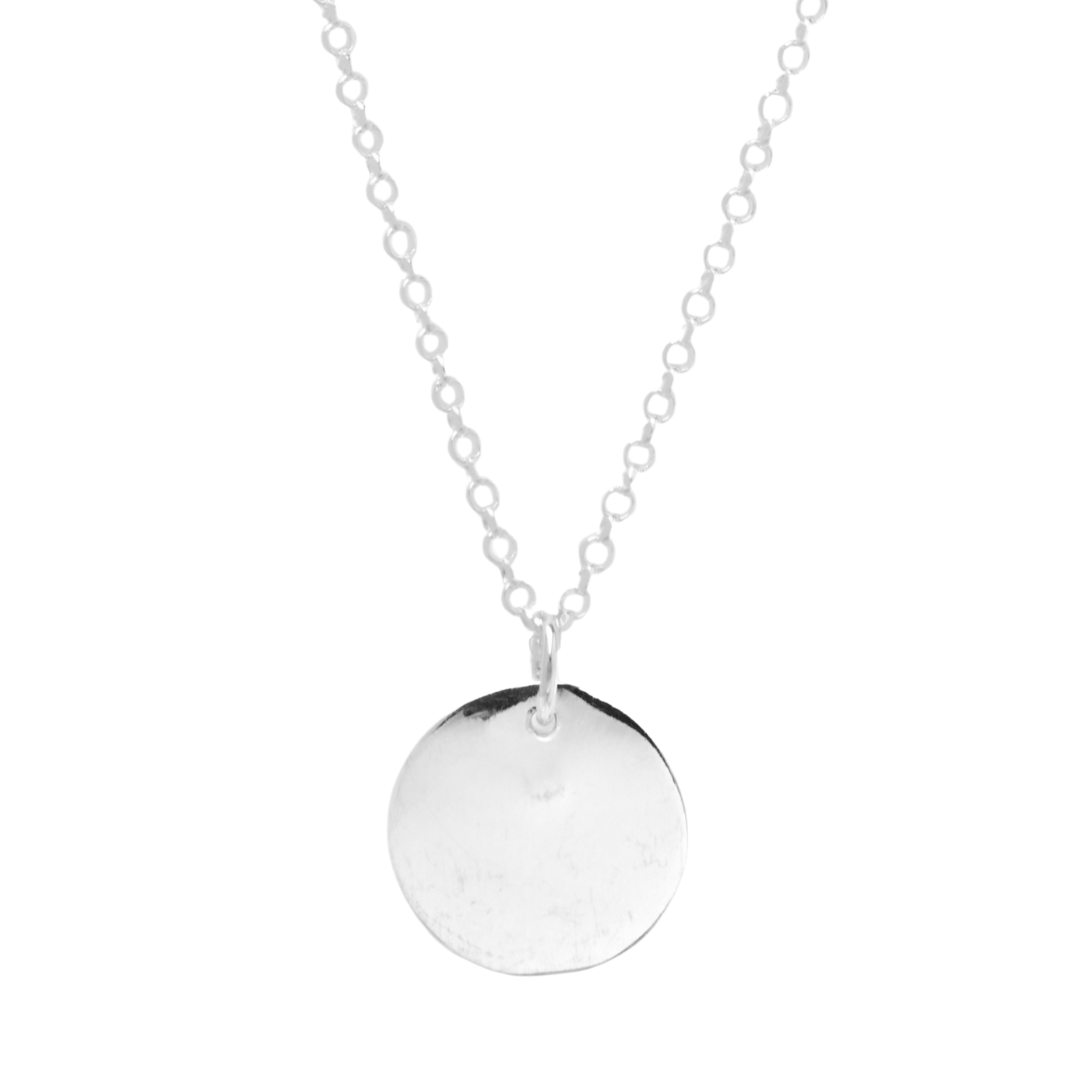 The Simple Disc Pendant by Personalised Charms is a delicate sterling silver necklace with a simple, round flat engraved pendant at the center.