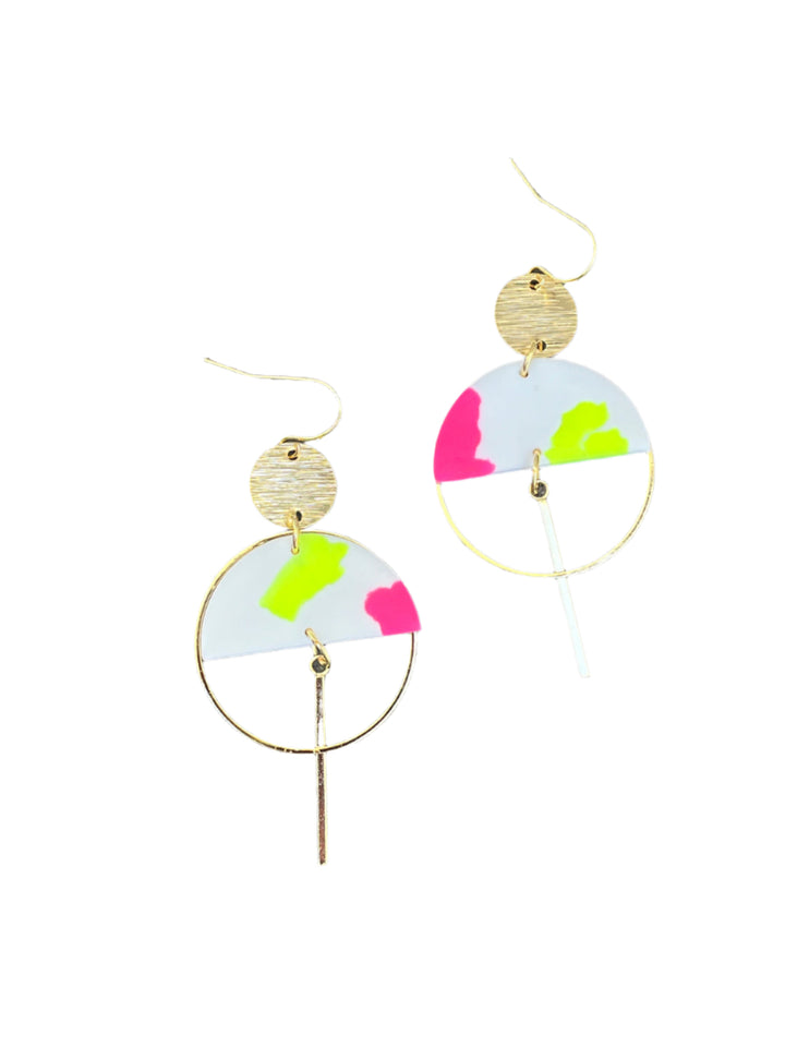The Sinead Earrings by Kybalion Jewellery feature modern gold plating, circular accents, white semicircles with neon pink and yellow colors, gold hoops, and a vertical bar, displayed on a textured wood surface.