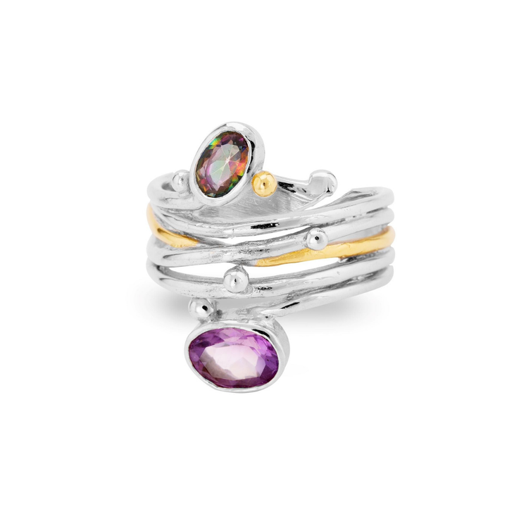 The Snake Ring in Silver Gold by Gallardo & Blaine Designs features layered silver bands, a thin gold stripe, small silver beads, and two bezel-set oval gemstones—one green and one purple.