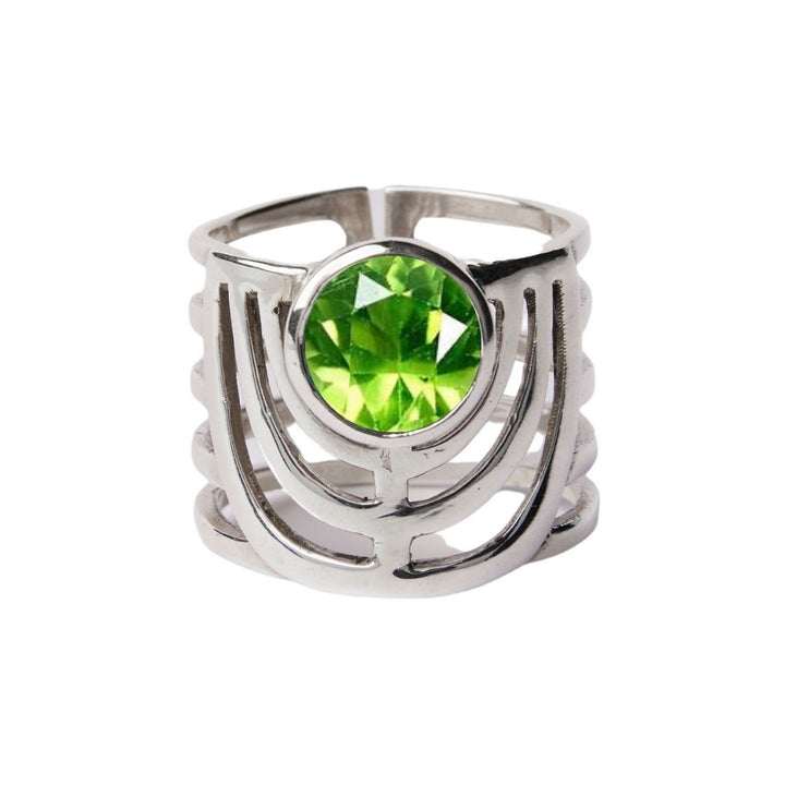 The Solar Ring by Gallardo & Blaine Designs features a chunky, open geometric design in sterling silver with a bold round green gemstone at the center.