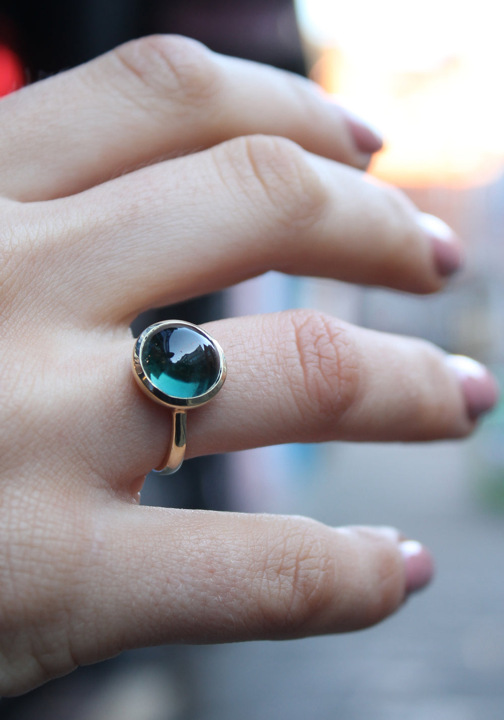 9ct yellow gold ring with a round dark green tourmaline cabochon in a bezel setting. The 9ct yellow gold band is D shaped widest at the back at 3mm wide. Shown here on a ring finger.