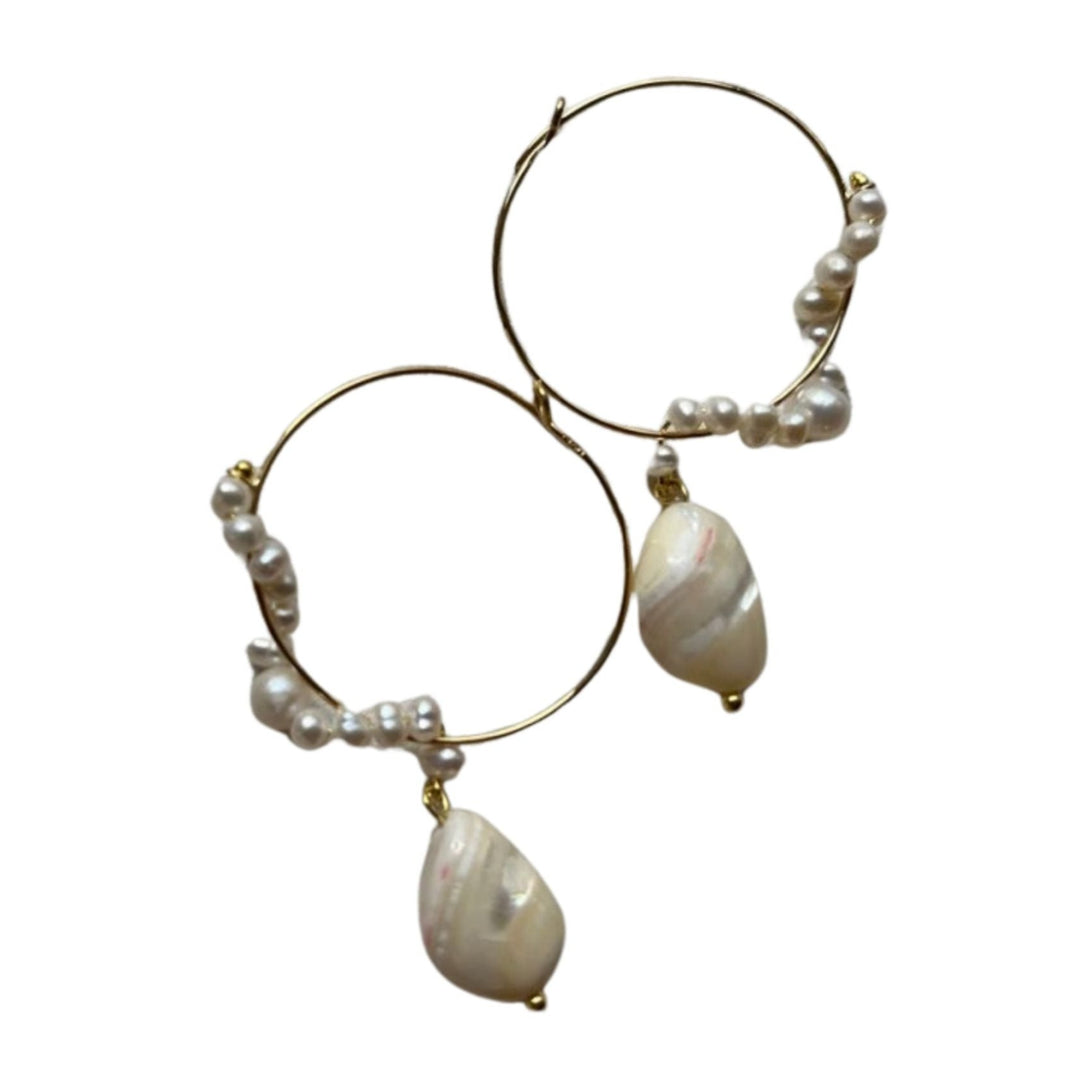 The Milkwhite Gold & Pearl Hoop Earrings adorned with small pearls and featuring a larger, teardrop-shaped pearl dangling from each hoop. The irregularly shaped pearls give the earrings a unique and natural look. Set against a plain white background, these stunning pieces by Bonvo are meticulously crafted with gold-plated sterling silver.