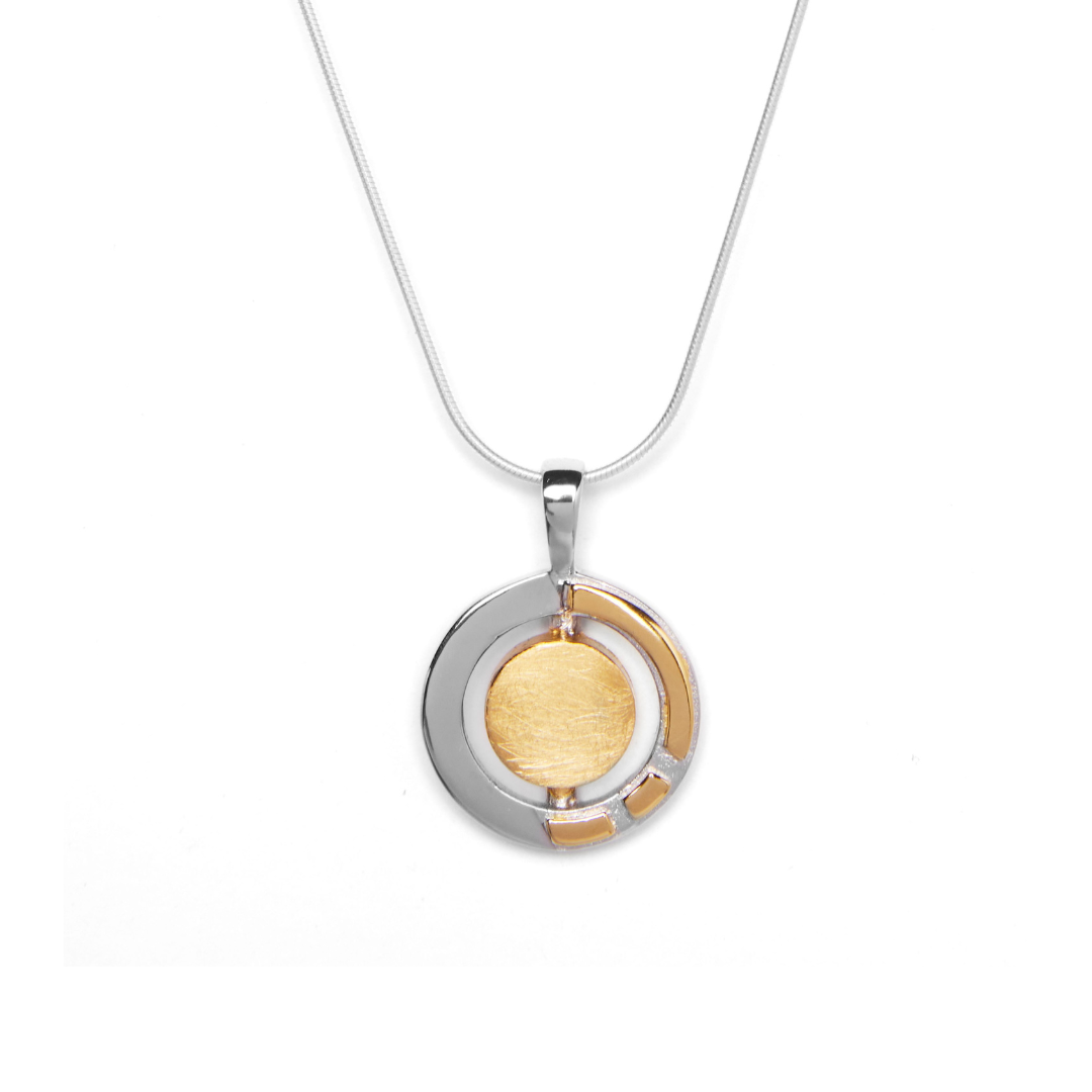 The Urú Small Pendant & Chain by Gallardo & Blaine Designs features a round sterling silver pendant with a brushed gold-toned center, shiny silver outer ring, and gold accents inspired by classic Irish jewelry.