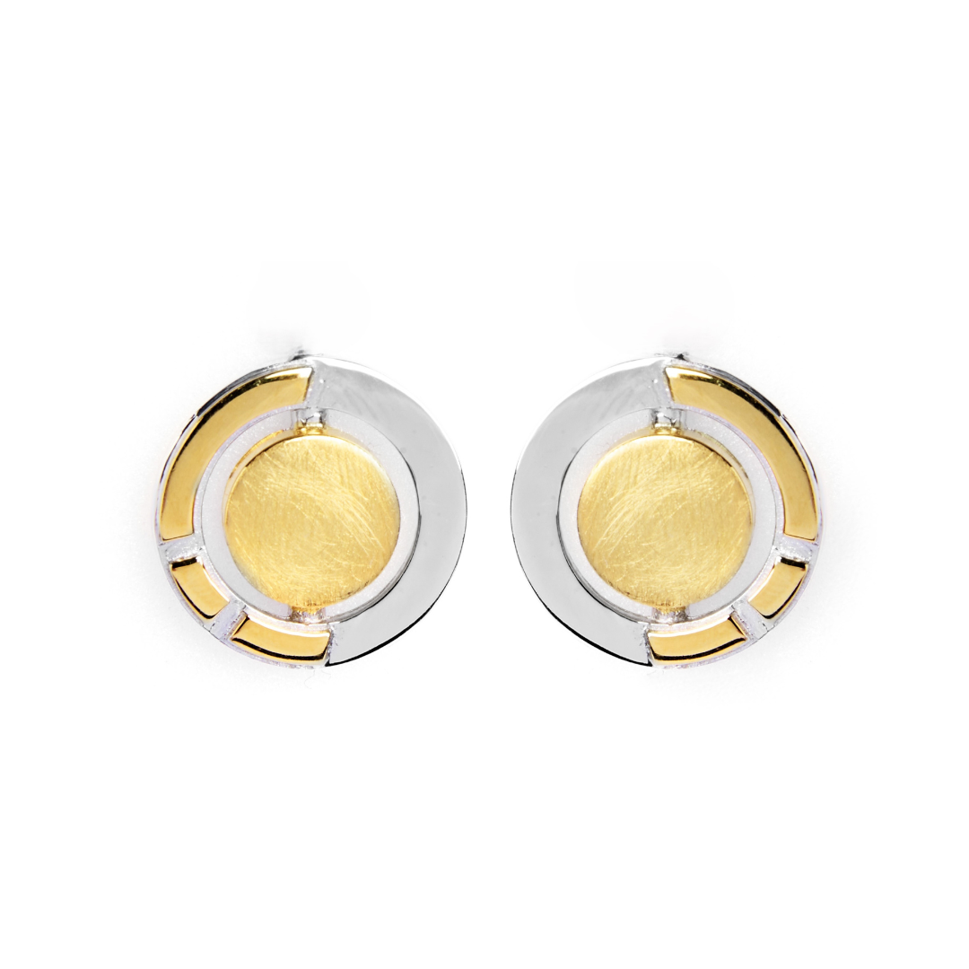The Urú Studs by Gallardo & Blaine Designs feature round Celtic-inspired earrings with a central gold-toned circle, sterling silver outer ring, and geometric gold accents—a timeless nod to classic Irish jewellery, shown on a white background.