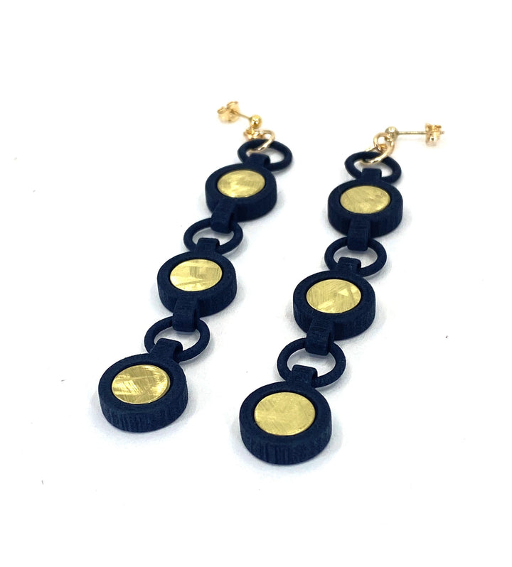 The Elsiem Vibe 3 Drop Earrings feature three linked black circles with gold centers on gold filled posts, shown against a white background.