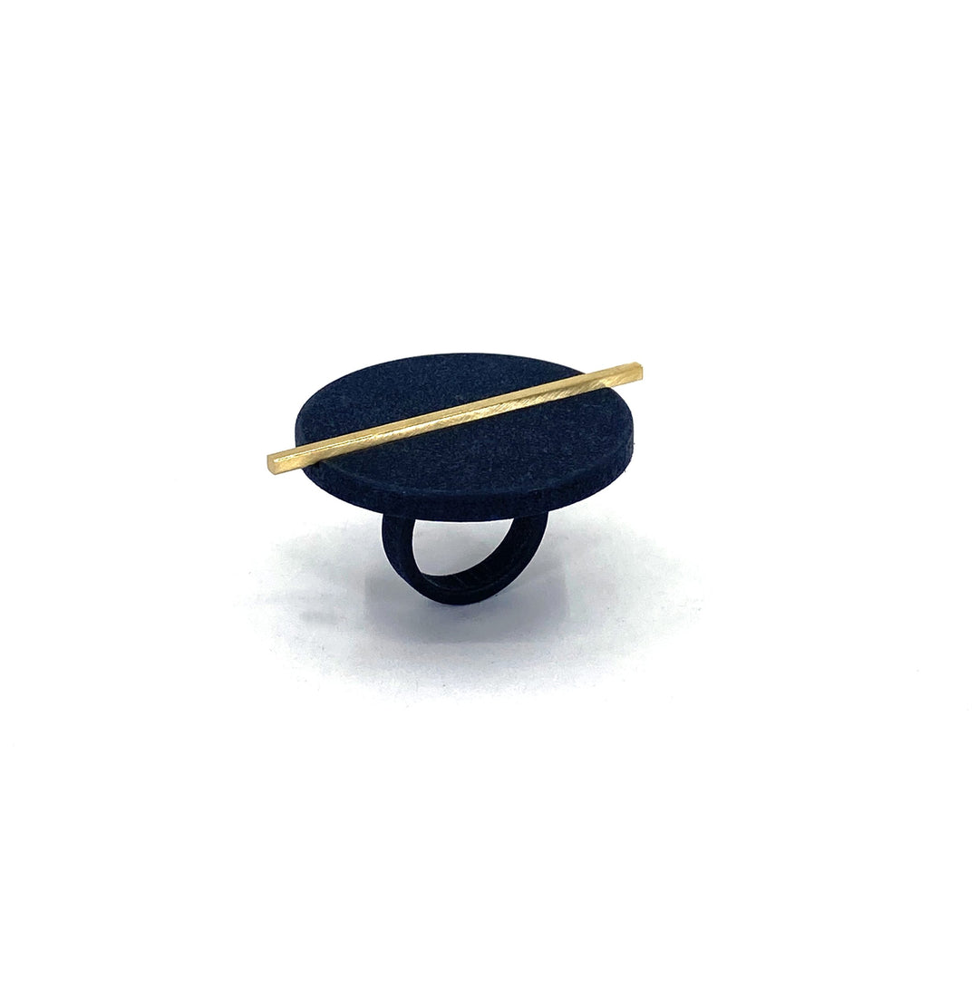 The Elsiem Vibe Disc & Bar Ring is a modern statement piece with a large matte black circular top, accented by a thin gold bar. Crafted from durable SLS Nylon, it stands out against a plain white background.