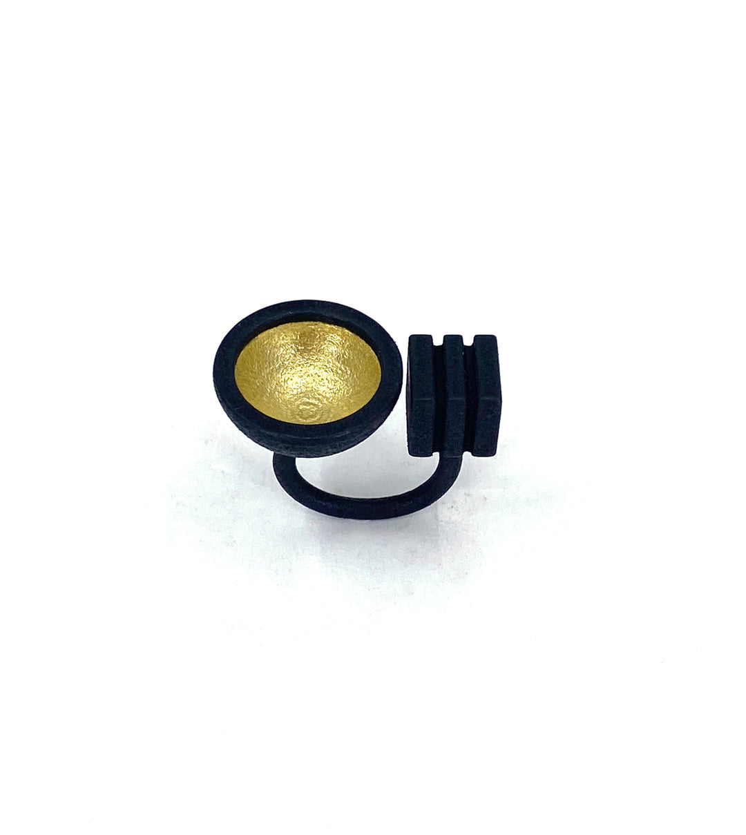 The Elsiem Vibe Gold Dome & Cube Ring features a matte black 3D printed band with a round, concave gold centerpiece and three vertical black bars, shown against a white background.