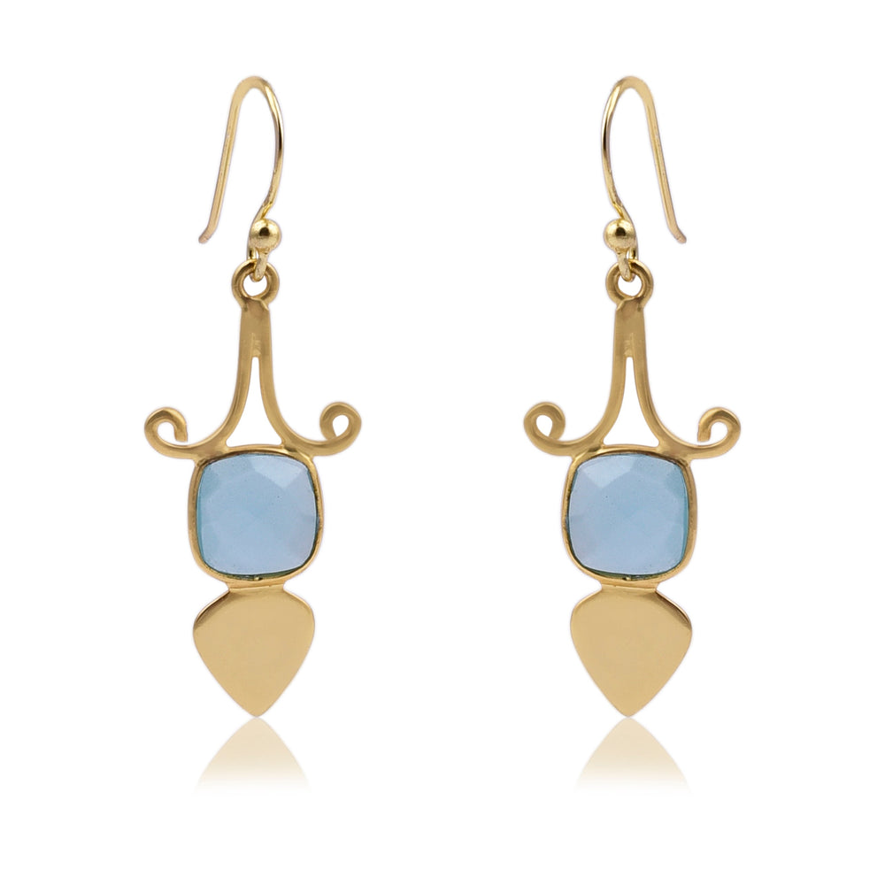 A pair of elegant Gold Shield Aqua Chalcedony Earrings by Watermelon Tropical featuring a curved design at the top, with a square blue gemstone in the center, and ending with a teardrop-shaped gold piece at the bottom. These exquisite pieces of handmade jewellery have hook closures.