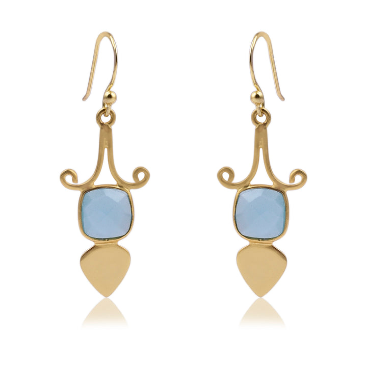 A pair of elegant Gold Shield Aqua Chalcedony Earrings by Watermelon Tropical featuring a curved design at the top, with a square blue gemstone in the center, and ending with a teardrop-shaped gold piece at the bottom. These exquisite pieces of handmade jewellery have hook closures.
