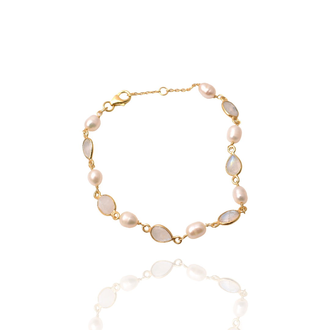 The Pearl & Rainbow Moonstone Bracelet by Watermelon tropical showcases alternating oval pearls and pearlescent rainbow moonstones, elegantly displayed on a white background with a soft reflection.