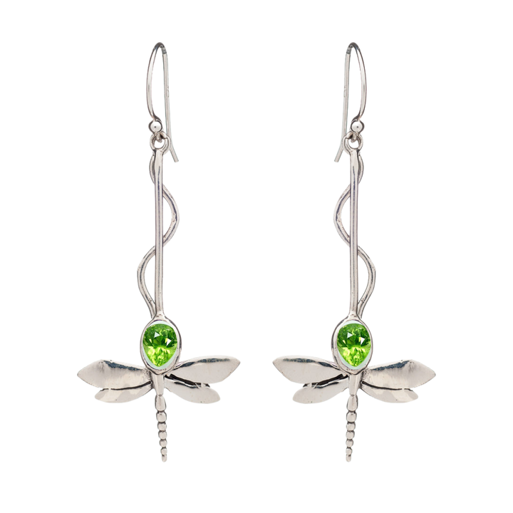 The Willow Earrings in Various Gemstones by Gallardo & Blaine Designs are silver dragonfly danglers with green gemstone bodies, curved decorative hooks, and intricately detailed wings.