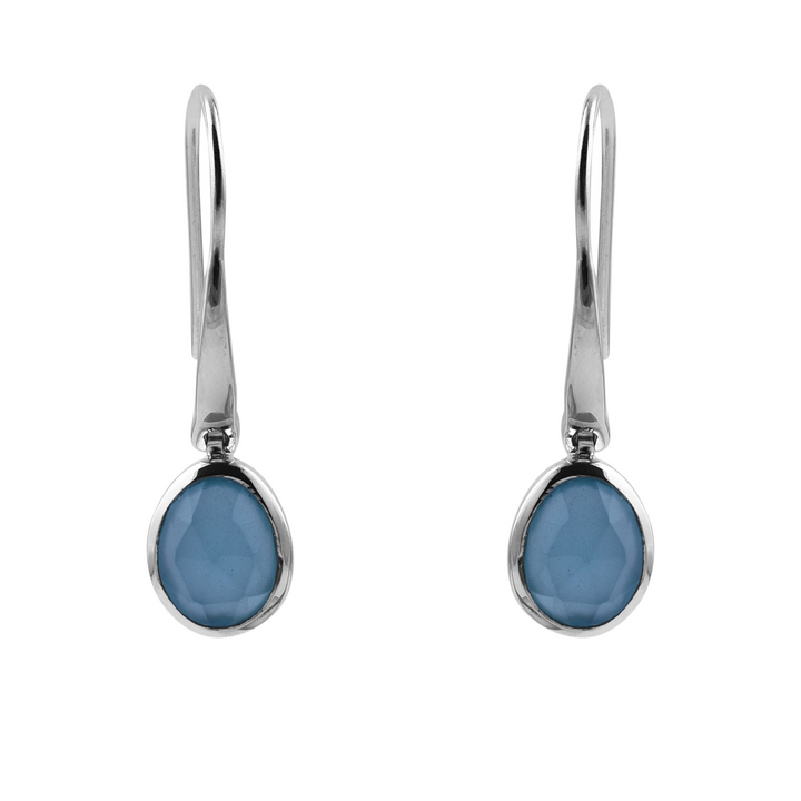 The Aqua Chalcedony Earrings by Watermelon Tropical feature oval-shaped aqua chalcedony gemstones encased in sleek sterling silver bezels. Emphasizing a modern design with a hook-style fastening, these earrings stand out elegantly against a plain white backdrop.
