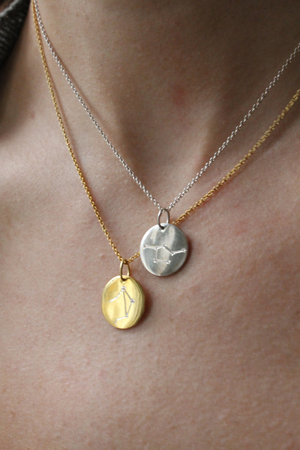 The Symbol Necklace by Personalised Charms features two layered engraved discs—one gold, one silver—with minimalist constellation designs, perfect for wearing as personalized jewelry.
