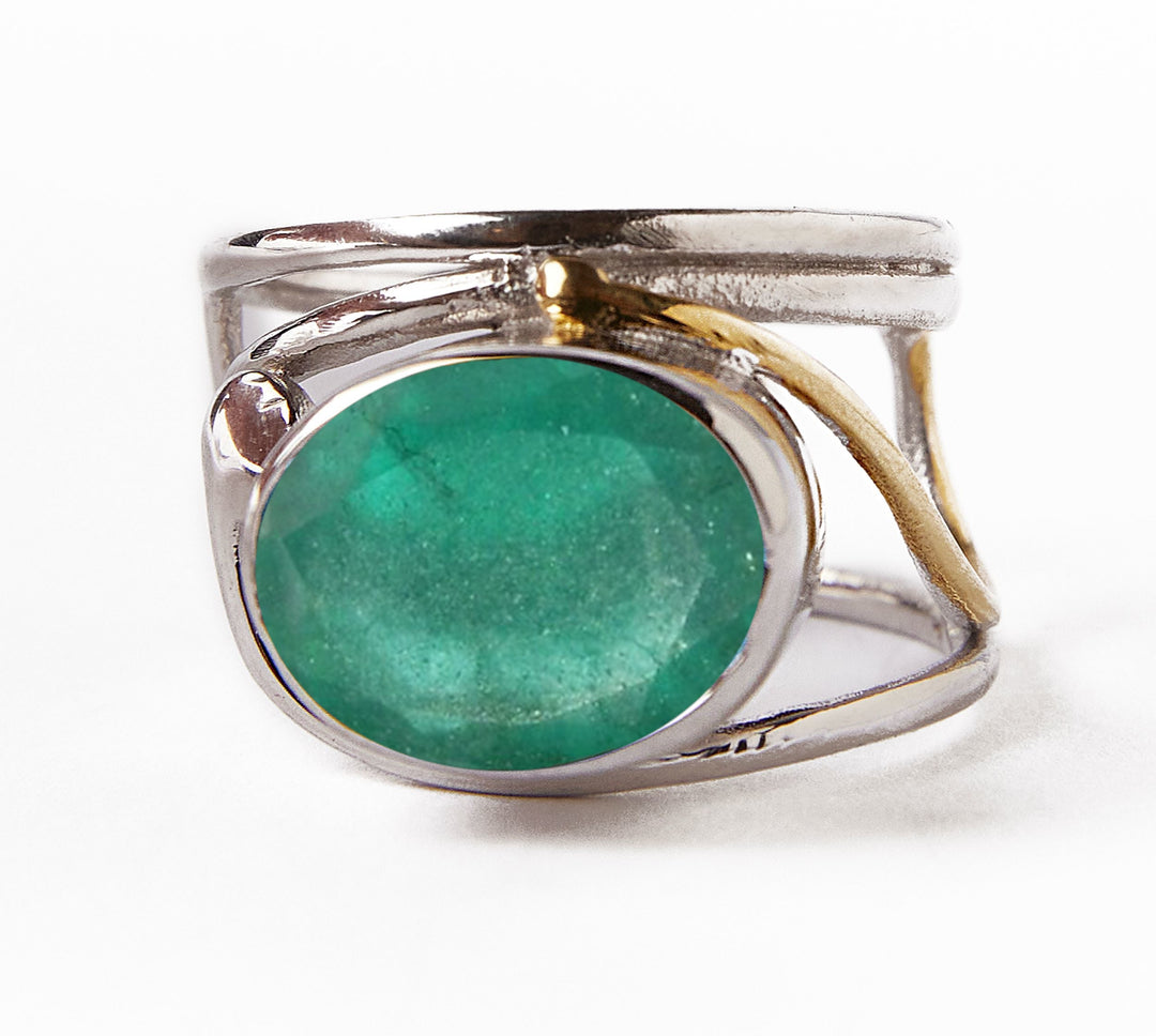The Gallardo & Blaine Designs' Horizontal Ring, available in various gemstones, features a large oval green center stone with a gold accent on one side. Its silver and gold-plated open band adds elegance against the plain white backdrop.